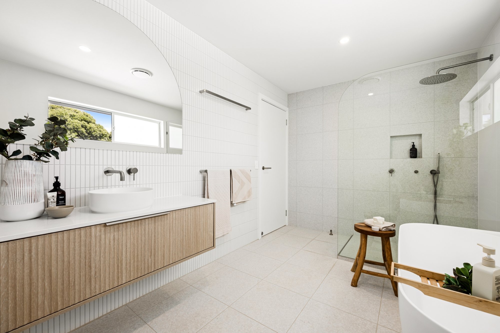 Small bathroom interior design with gold detail, pink basin and neutral tile